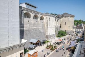 - un grand bâtiment en pierre avec des personnes se déplaçant autour de lui dans l'établissement Au pied du château d'Amboise, à Amboise