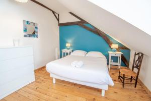 1 dormitorio con cama blanca y pared azul en Au pied du château d'Amboise, en Amboise