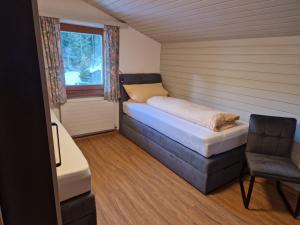 um pequeno quarto com uma cama e uma janela em Haus Gabi em Neustift im Stubaital