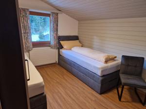 ノイシュティフト・イム・シュトゥーバイタールにあるHaus Gabiのベッドと窓が備わる小さな客室です。