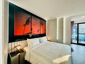 1 dormitorio con 1 cama y una gran pintura en la pared en 水秀一方Sun Moon Lakeside Boutique Hotel en Yuchi