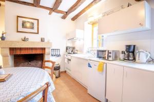 FrancueilGîte Wanouchka - comfort in the countryside!的房间里有白色橱柜和桌子的厨房