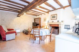 FrancueilGîte Wanouchka - comfort in the countryside!的厨房以及带桌子和壁炉的客厅。