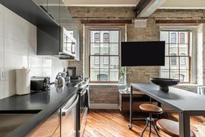 een keuken met zwarte werkbladen en een groot raam bij Ironworks Building in New Orleans