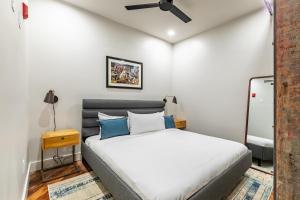 a bedroom with a white bed with blue pillows at Ironworks Building- 1 Bedroom 1 Bath in New Orleans