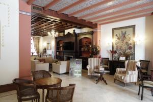 hol z krzesłami i stołami oraz salon w obiekcie Hospedarte Palacete Real w mieście El Rocío