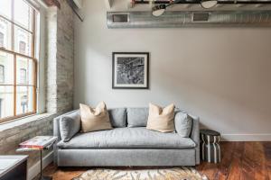 een woonkamer met een grijze bank en een raam bij Ironworks Building in New Orleans