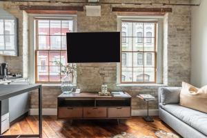 een woonkamer met een flatscreen-tv op een bakstenen muur bij Ironworks Building in New Orleans +125 foto's