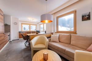 uma sala de estar com um sofá e uma mesa em Ferienwohnung Gipfelreich em Bramberg am Wildkogel
