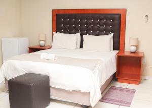 a bedroom with a large bed with a black headboard at Mohlaletse Guest House in Ga-Matsi