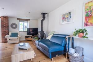 a living room with a blue couch and a tv at Christmas Barn in Snettisham