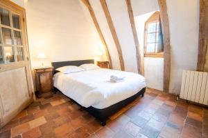 ein Schlafzimmer mit einem großen Bett in einem Zimmer in der Unterkunft Pavillon de chasse XVI siècle - Château de Nitray in Athée-sur-Cher