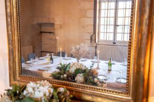 einen Tisch im Spiegel mit Blumen drauf in der Unterkunft Pavillon de chasse XVI siècle - Château de Nitray in Athée-sur-Cher