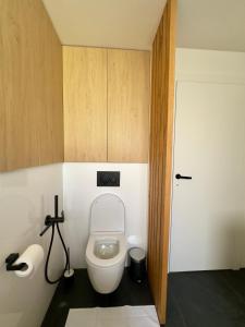 a bathroom with a white toilet in a room at Apartmán Olívia in Šamorín