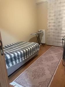 1 dormitorio con cama, mesa y alfombra en Site, en Estambul
