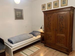 1 dormitorio con 1 cama y armario de madera en Apartman Slonek, en Nové Město na Moravě