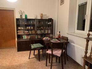 a dining room with a table and a book shelf at Apartman Slonek in Nové Město na Moravě