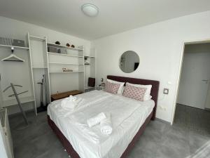 una camera da letto con un grande letto con lenzuola e cuscini bianchi di strandnahe FeWo mit Schwimmbad im Haus, a cappella 03, Binz a Binz