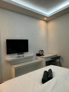 a bedroom with a bed with a flat screen tv at D SEGA HOTEL in Macang