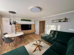 sala de estar con sofá verde y mesa en Apartmán Olívia, en Šamorín