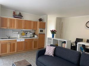 uma sala de estar com um sofá e uma cozinha em strandnahe FeWo mit Schwimmbad im Haus, a cappella 03, Binz em Binz