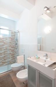een badkamer met een wastafel, een toilet en een spiegel bij Appartamento vista mare! in Fano