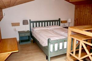 a bedroom with a bed and a table with a lamp at Fiemme Village in Bellamonte