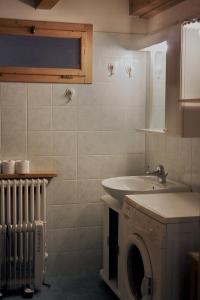łazienka z umywalką i pralką w obiekcie Fiemme Village w mieście Bellamonte
