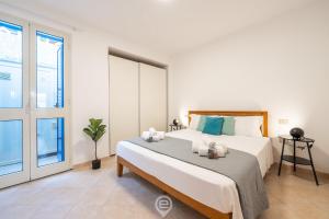 - une chambre avec un grand lit et une grande fenêtre dans l'établissement Azure House, à Calasetta