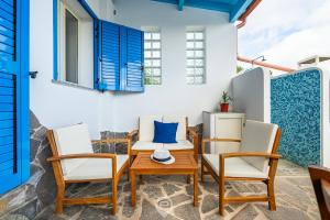 d'une terrasse avec une table, des chaises et des volets bleus. dans l'établissement Azure House, à Calasetta