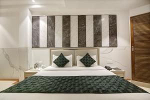 a bedroom with a large white bed with two pillows at Hotel Transit International- Aerocity Delhi Airport in New Delhi