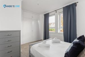 1 dormitorio con 1 cama, vestidor y ventana en Secluded 2 bed apartment Edinburgh, en Edimburgo