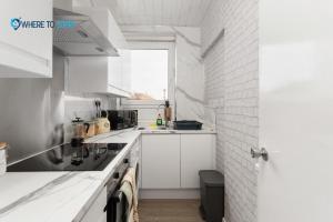 a kitchen with white cabinets and a window at Secluded 2 bed apartment Edinburgh in Edinburgh