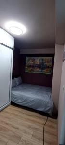 een kleine slaapkamer met een bed in de hoek bij Mavrovo Grey Residence in Mavrovo