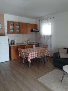 eine Küche und ein Wohnzimmer mit einem Tisch und Stühlen in der Unterkunft Apartman Mima in Porat