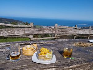 a table with a bowl of food and two glasses of beer at Arrantzale Beach in Bermeo