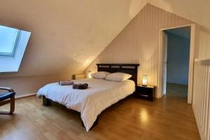 a bedroom with a large bed with two bags on it at Charmant duplex a deux pas du lac in Sévrier