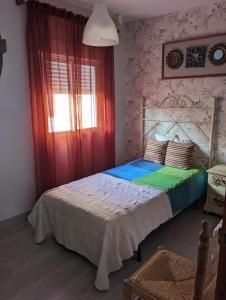a bedroom with a bed with a red curtain at Apartamento Turístico Monteceli AT-CC-00748 in Gata