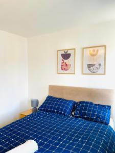 um quarto com uma cama azul e 2 almofadas azuis em Sittingbourne, Kent em Kent