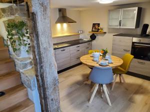 cocina con mesa de madera y sillas amarillas en Donauwelle, en Sigmaringendorf