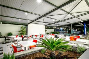 een restaurant met witte tafels en rode stoelen bij Design Hostel 101 Dalmatinac in Split