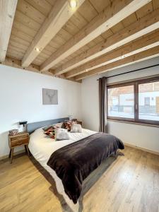 ein Schlafzimmer mit einem großen Bett und einem Fenster in der Unterkunft Chalet Le Daim in La Toussuire
