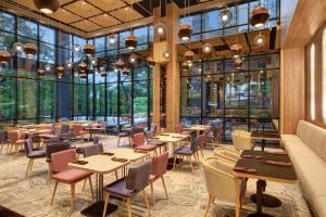 een restaurant met tafels en stoelen en grote ramen bij ibis Styles Serpong BSD City in Tangerang