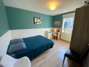 um quarto azul com uma cama e uma secretária em Maison chic avec Jacuzzi & Jardin Paisible em Chauray