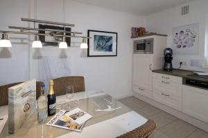 a kitchen with a table with wine bottles and chairs at Haus Möwe 5/13 in Hörnum