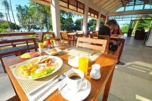 una mesa con un plato de comida y una taza de café en Isle Beach Resort Krabi-SHA en Klong Muang Beach