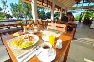 una mesa con un plato de comida y una taza de café en Isle Beach Resort Krabi-SHA, en Klong Muang Beach