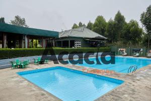 a swimming pool in front of a building at Acacia Country Inn in Mbarara