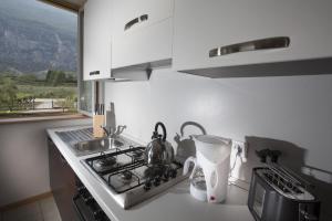 kuchnia z kuchenką, umywalką i oknem w obiekcie Appartamenti Al Vigneto w mieście Dro