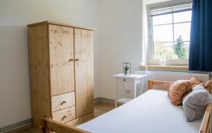 a bedroom with a bed and a cabinet and a window at Chalet Nordwald 